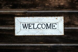 A rustic vintage-style 'Welcome' sign on a wooden wall creating a warm and inviting atmosphere.